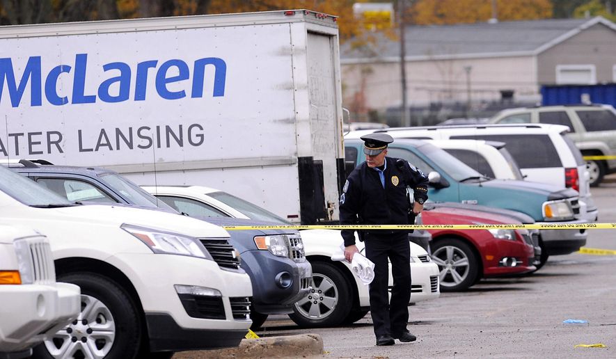 Lansing Police investigate the scene of a double fatal shooting in the parking lot behind the McLaren Greater Lansing Pennsylvania campus in Lansing, Mich., Tuesday, Oct. 21, 2014. Lansing police say two people are dead after a murder-suicide in a hospital parking lot. (AP Photo/Lansing State Journal, Rod Sanford) NO SALES