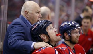 Washington Capitals head coach Barry Trotz puts his hand on Washington Capitals left wing Jason Chimera (25) on the bench in the third period of an NHL hockey game against the Florida Panthers, Saturday, Oct. 18, 2014, in Washington. The Capitals won 2-1, in a shootout. (AP Photo/Alex Brandon)