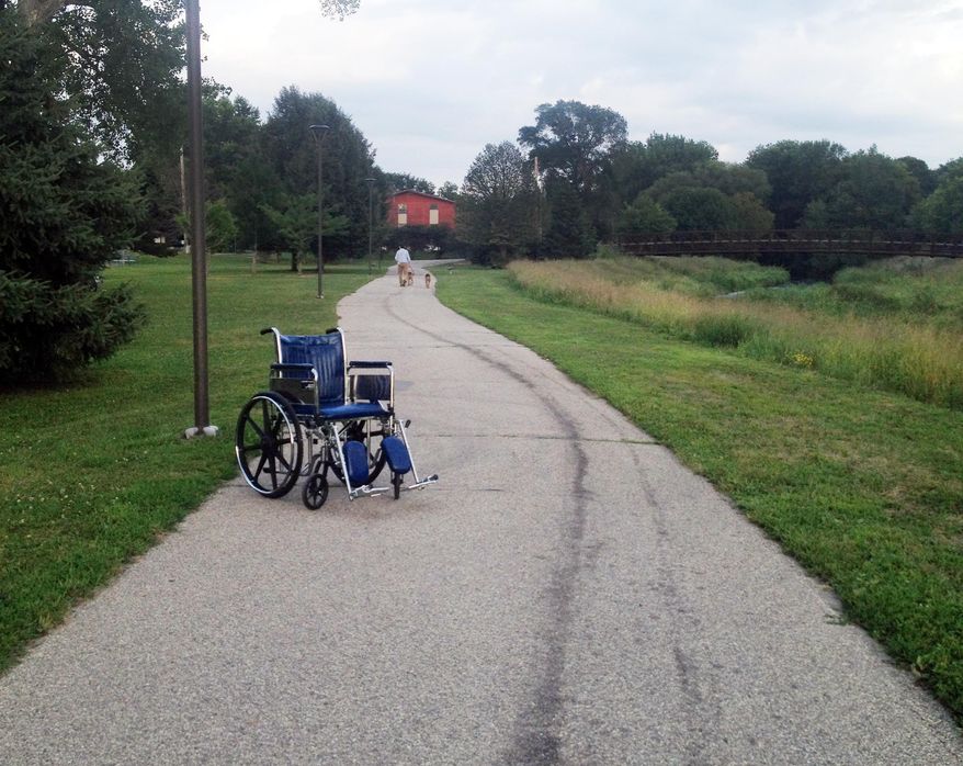 In this Aug. 20, 2014 photo, an abandoned Mayo Clinic wheelchair sits at rest on the Cascade Creek walking trail near Kutzky Park in Rochester, Minn. In Minnesota's "Med City," wheelchairs are commonplace, and they sometimes end up abandoned in unusual places, such as parking ramps and downtown sidewalks. (AP Photo/Minnesota Public Radio, Elizabeth Baier)
