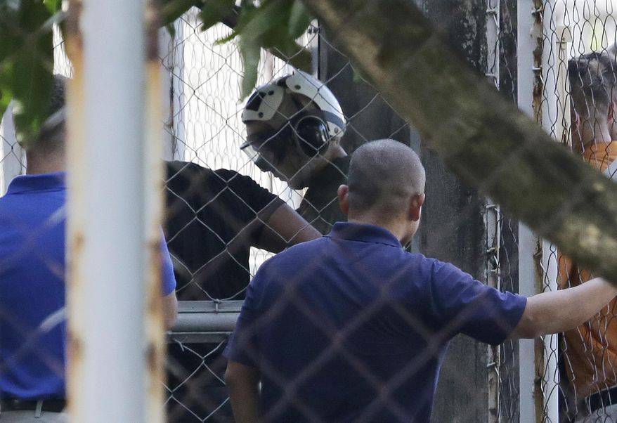 U.S. Marine Pfc. Joseph Scott Pemberton, a suspect in the gruesome killing of a transgender Filipino woman, arrives inside the compound of the Camp Aguinaldo military headquarters in suburban Quezon city, north of Manila, Philippines, Wednesday, Oct. 22, 2014. The Philippine military chief says Pemberton has been flown to the main Philippine military camp in the capital, easing a looming irritant with Washington over his custody, officials said. (AP Photo/Aaron Favila)