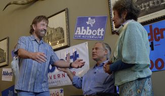 Republican gubernatorial candidate Greg Abbott, middle, introduces actor Chuck Norris to his mother-in-law, Mary Lucy Phalen, during a campaign event at the Casa Rio restaurant in San Antonio, Texas, on Wednesday, Oct. 22, 2014. (AP Photo/San Antonio Express-News, Billy Calzada)
