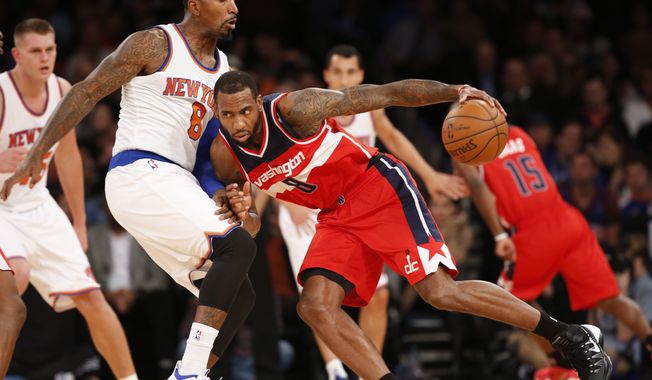 Washington Wizards forward Rasual Butler, right, drives into New York Knicks guard J.R. Smith, front left,in the first half of an NBA basketball game at Madison Square Garden in New York, Wednesday, Oct. 22, 2014. The Knicks defeated the Wizards 103-100. (AP Photo/Kathy Willens)
