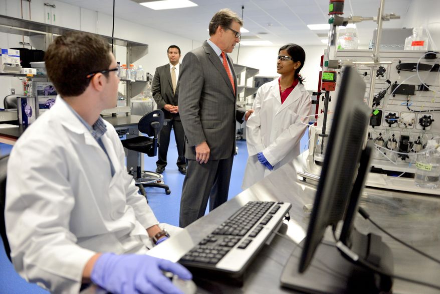 Texas Gov. Rick Perry speaks with Texas A&M bio technology gradate student Deepa Vijaykomar, right, during a tour of the Texas A&M National Center for Therapeutics Manufacturing in College Station, Texas, Wendesday, Oct. 22, 2014. The center is one of the pioneering vaccine and therapeutic manufacturing facilities that comprise the Texas A&M Center for Innovation in Advanced Development and Manufacturing (CIADM). (AP Photo/The Bryan-College Station Eagle, Sam Craft) MANDATORY CREDIT