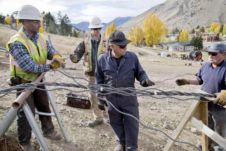 In this Oct. 16, 2014 photo, Norm Duke, center, surveys the jumbled mass of untwined ends of the Summit Chairlift's new haul cable at Snow King Mountain in Jackson, Wyo. Duke is one of only a handful of cable splicers in the country.(AP Photo/Jackson Hole News & Guide, Bradly J. Boner) MANDATORY CREDIT; MAGS OUT; NO SALES