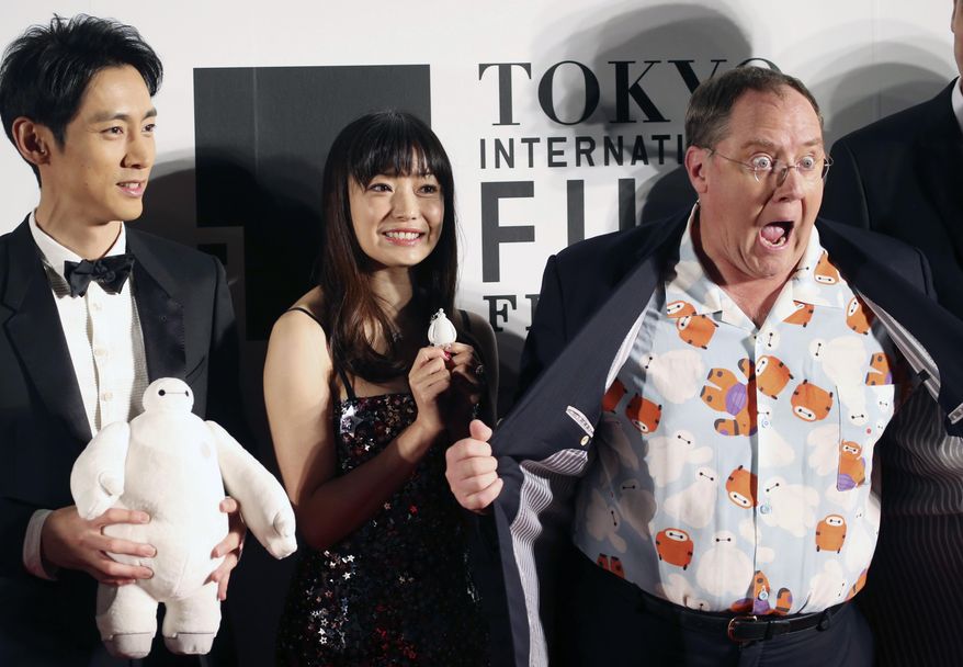FILE - In this Thursday, Oct. 23, 2014 file photo, John Lasetter, right, chief creative officer at Pixar, Walt Disney Aniamation Studios and Disney Toon Studios, poses for a photo with Japanese actors, Miho Kanno, center, and Kotaro Koizumi, both holding a character of "Baymax," the inflatable marshmallow-like robot in the animation movie "Big Hero 6," during an opening ceremony of the 27th Tokyo International Film Festival in Tokyo. Disney executives call their next film “a love letter to Japanese culture.” No wonder: This nation can’t get enough of animation, especially Disney’s. (AP Photo/Koji Sasahara, File)