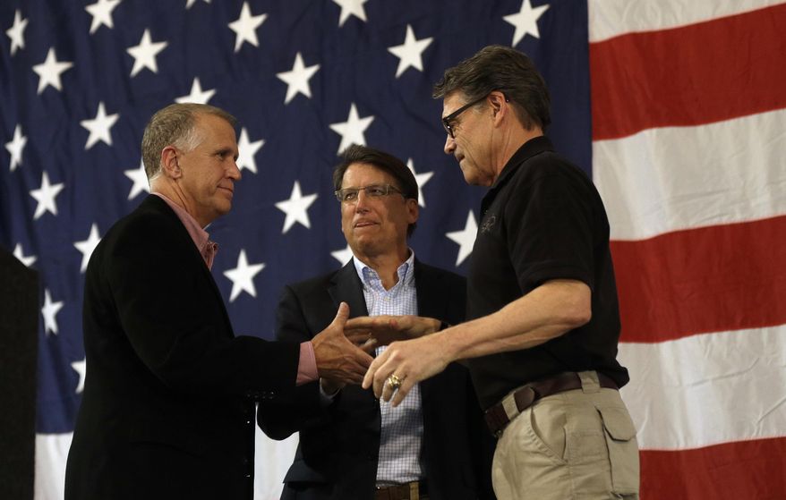 U.S. Senate candidate and Speaker of the North Carolina House Thom Tillis, left, North Carolina Gov. Pat McCrory and Texas Gov. Rick Perry shake hands during a conservative rally in Smithfield, N.C., Friday, Oct. 24, 2014. (AP Photo/Gerry Broome)