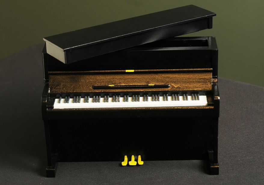 In this Oct. 23, 2014 photo, a composite ceramic custom printed 3-D funeral urn depicting a piano, made by Foreverence, is seen in Eden Prairie, Minn. Foreverence sells the urns via funeral directors, The St. Paul Pioneer Press reported. (AP Photo/The St. Paul Pioneer Press, Scott Takushi)