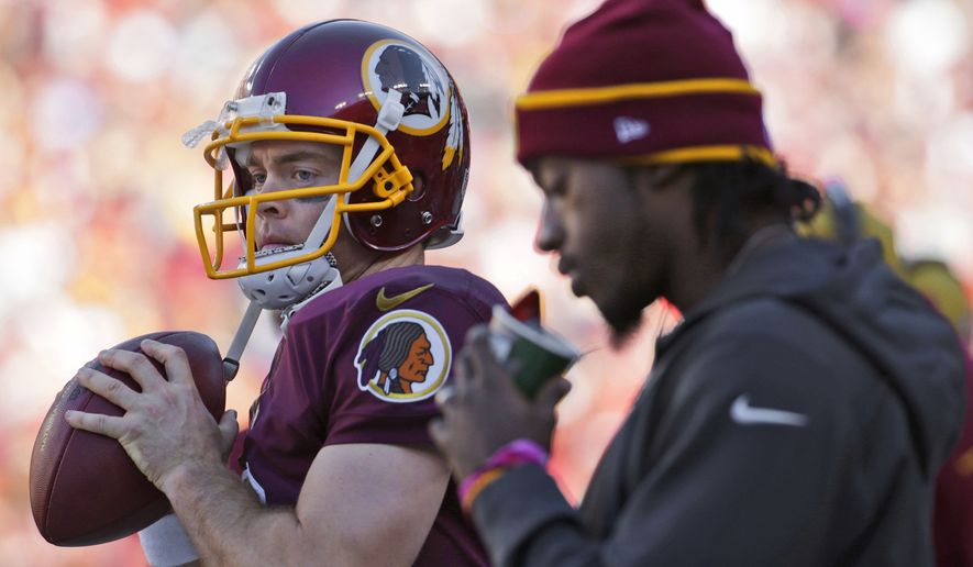 Washington Redskins quarterbacks Colt McCoy, left, and Robert Griffin III, right, on the sidelines during the second half of a NFL football game against the Tennessee Titans, Sunday, Oct. 19, 2014. at Fedex Field in Landover, MD. (AP Photo/Pablo Martinez Monsivais)
