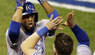 Kansas City Royals&#39; Alcides Escobar is congratulated by teammate Mike Moustakas after scoring during the sixth inning of Game 3 of baseball&#39;s World Series against the San Francisco Giants Friday, Oct. 24, 2014, in San Francisco. (AP Photo/Eric Risberg) 