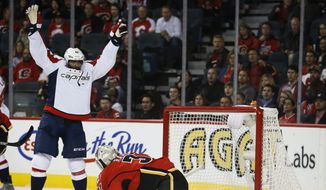 Washington Capitals&#39; Joel Ward, left, celebrates his goal as Calgary Flames goalie Karri Ramo, from Finland, reacts during the second period of an NHL hockey game Saturday, Oct. 25, 2014, in Calgary, Alberta. (AP Photo/The Canadian Press, Jeff McIntosh)