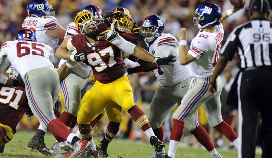 Washington Redskins defensive end Jason Hatcher (97) fights to get to New York Giants quarterback Eli Manning (10) in the third quarter at FedExField, Landover, Md., Sept. 25, 2014. (Preston Keres/Special for The Washington Times)
