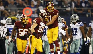 Washington Redskins&#39; Ryan Kerrigan, top, celebrates with Trent Murphy (93) after Murphy recovered a Dallas Cowboys fumble during the first half of an NFL football game, Monday, Oct. 27, 2014, in Arlington, Texas. (AP Photo/Tim Sharp)