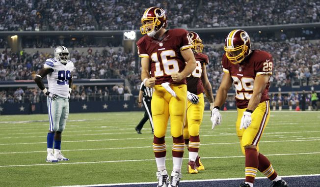 Washington Redskins&#x27; Colt McCoy (16) and Roy Helu (29) celebrate after McCoy scored a touchdown on a run during the second half of an NFL football game against the Dallas Cowboys, Monday, Oct. 27, 2014, in Arlington, Texas. Cowboys&#x27; George Selvie (99) watches from the rear. (AP Photo/Tim Sharp)