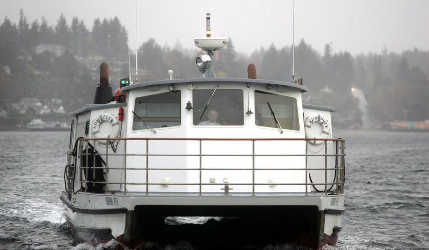 Admiral Pete passenger ferry captain Bill Nearhoff pilots the ship into the Bremerton dock on a gray wet morning. He has been piloting the little ferries across Sinclair Inlet since 1961. (AP Photo/Kitsap Sun, Larry Steagall)