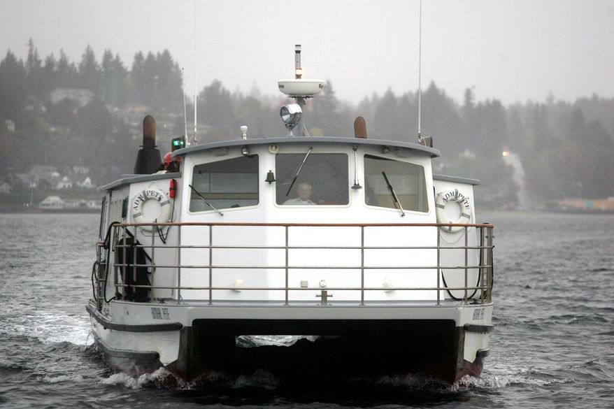 Admiral Pete passenger ferry captain Bill Nearhoff pilots the ship into the Bremerton dock on a gray wet morning. He has been piloting the little ferries across Sinclair Inlet since 1961. (AP Photo/Kitsap Sun, Larry Steagall)
