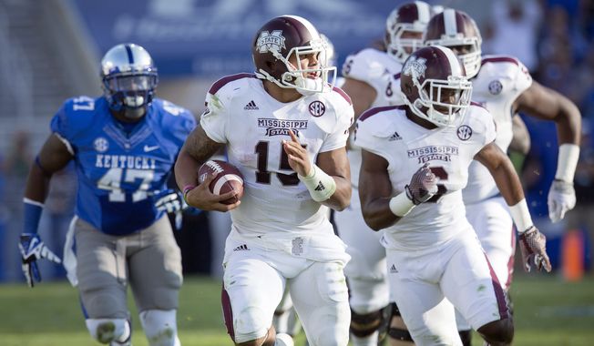 Mississippi State quarterback Dak Prescott, center, runs for a first down during the first half of an NCAA college football game against Kentucky at Commonwealth Stadium in Lexington, Ky., Saturday, Oct. 25, 2014. (AP Photo/David Stephenson)