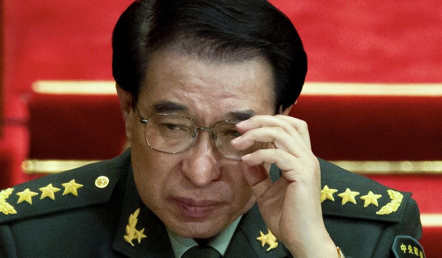 In this March 11, 2012 photo, Xu Caihou, then deputy chairman of the CPC Central Military Commission, which controls China&#39;s military adjusts his glasses during a plenary session of the National People&#39;s Congress at the Great Hall of the People in Beijing, China. Chinese prosecutors have indicted the former top military leader on bribery charges, state media said Tuesday, Oct. 28, 2014. (AP Photo/Andy Wong)