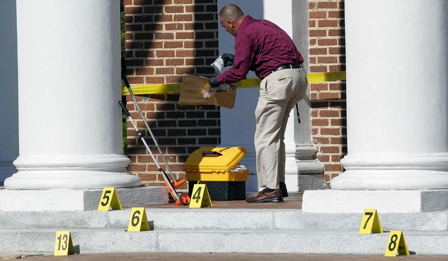 Crime scene investigator Larry Bryant with the Nash Co. Sheriff&#39;s Dept. gathers evidence from the courthouse steps after two people were shot in front of the Nash Co. Courthouse in Nashville, N.C. on Tuesday, Oct. 28, 2014. A manhunt involving helicopters and dozens of armed officers patrolling a nearby highway was underway for two men who Nash County Sheriff Dick Jenkins said fled in a white car. (AP Photo/The News &amp;amp; Observer, Chris Seward)