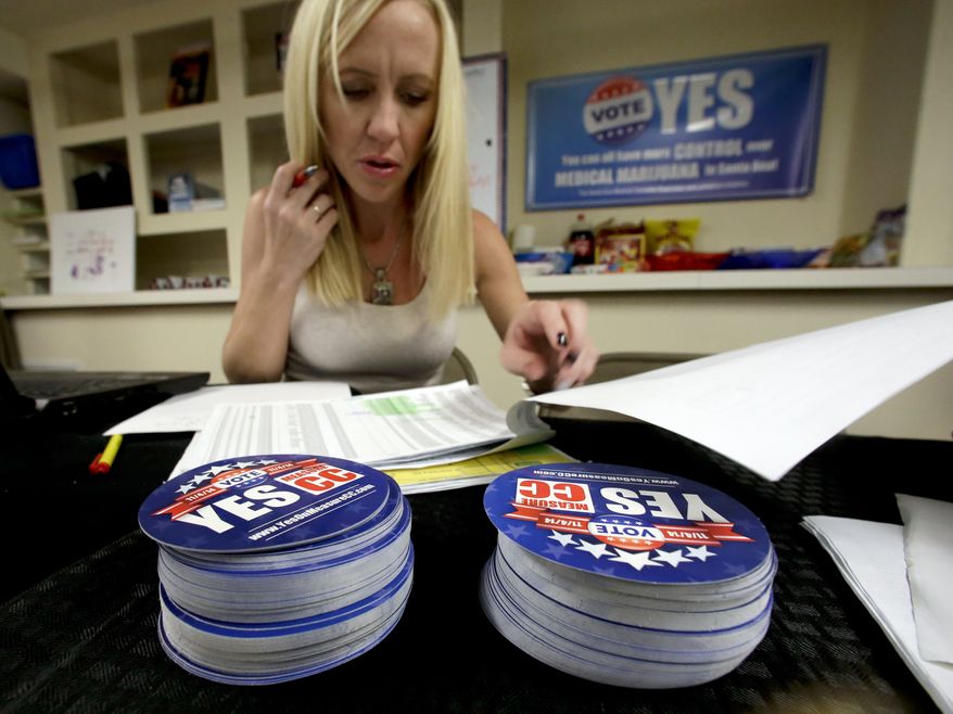 Lindsey Kelly works at the campaign office for the Yes on CC measure, Thursday, Oct. 23, 2014 in Santa Ana, Calif. Measure CC regulates and controls medical cannabis dispensaries in the city of Santa Ana.  This fall, like several other cities and counties in California, Santa Ana is trying a new tactic for regulating pot,  the ballot box. Recognizing its losing battle against weed, the Santa Ana City Council is asking voters to consider a measure that would allow pot dispensaries under strict operating rules. (AP Photo/Chris Carlson)