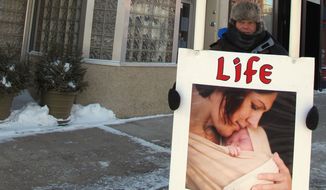 FILE - In this Feb. 20, 2013 file photo, an abortion protester stands outside the Red River Valley Women&#39;s Clinic in downtown Fargo, N.D. The director of North Dakota&#39;s sole abortion provider says medical abortions have ceased at the Fargo clinic following a North Dakota Supreme Court ruling Tuesday, Oct. 28, 2014, that upheld a 2011 state law limiting the use of drugs to perform abortions. (AP Photo/Dave Kolpack, File)