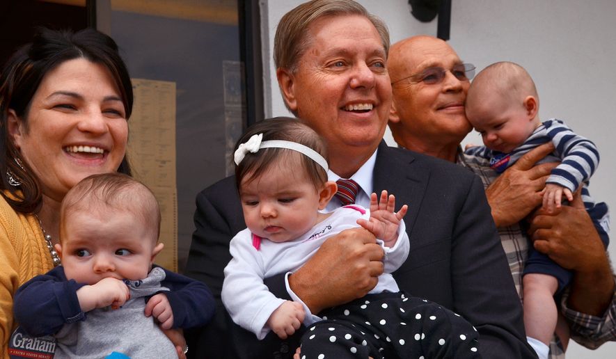 U.S. Sen Lindsey Graham holds 5-month-old Nora Omer, center, along with the triplet&#x27;s mother Angela Omer , holding Corbett, left, and grandfather Sheldon Waters, holding Oliver, back right, as the senator spoke with supporters and volunteers during a campaign stop at the Spartanburg GOP women&#x27;s group office, Wednesday, Oct. 29, 2014, in Spartanburg, S.C. (AP Photo/The Spartanburg Herald-Journal, Tim Kimzey)