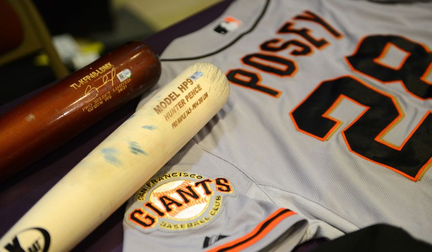 Bats from Salvador Perez of the Kansas City Royals and Hunter Pence of the San Francisco Giants are displayed with a champagne drenched World Series jersey from Buster Posey of the of the Giants during a display of World Series artifacts which were being delivered to the Baseball Hall of Fame and Museum in Cooperstown Thursday, Oct. 30, 2014, at Albany International Airport in Colonie, N.Y. (AP Photo/The Albany Times Union, Will Waldron) TROY, SCHENECTADY; SARATOGA SPRINGS; ALBANY OUT