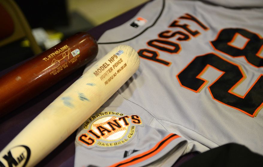 Bats from Salvador Perez of the Kansas City Royals and Hunter Pence of the San Francisco Giants are displayed with a champagne drenched World Series jersey from Buster Posey of the of the Giants during a display of World Series artifacts which were being delivered to the Baseball Hall of Fame and Museum in Cooperstown Thursday, Oct. 30, 2014, at Albany International Airport in Colonie, N.Y. (AP Photo/The Albany Times Union, Will Waldron) TROY, SCHENECTADY; SARATOGA SPRINGS; ALBANY OUT