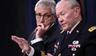 Defense Secretary Chuck Hagel listens at left as Joint Chiefs Chairman Gen. Martin E. Dempsey speaks during a briefing at the Pentagon, Thursday, Oct. 30, 2014. (AP Photo/Susan Walsh)