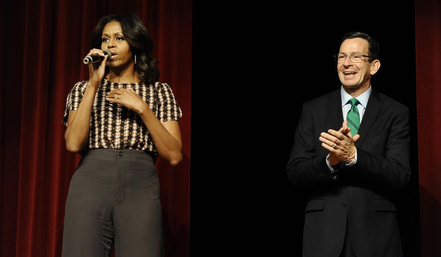 First Lady Michelle Obama, left, speaks as Connecticut Gov. Dannel P. Malloy listens after surprising a group of supporters in an overflow room to a rally, Thursday, Oct. 30, 2014, in New Haven, Conn. (AP Photo/Jessica Hill)