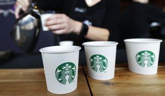 In this March 19, 2014, file photo, Sandy Roberts, Starbucks strategy manager for global coffee engagement, pours samples of coffee for shareholders and other guests, at Starbucks&#x27; annual shareholders meeting in Seattle. (AP Photo/Ted S. Warren, File)