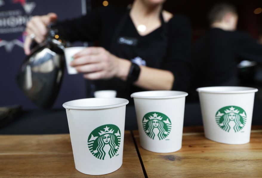 In this March 19, 2014, file photo, Sandy Roberts, Starbucks strategy manager for global coffee engagement, pours samples of coffee for shareholders and other guests, at Starbucks&#x27; annual shareholders meeting in Seattle. (AP Photo/Ted S. Warren, File)