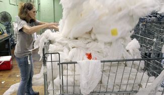 In this photo taken on Sept. 17, 2014, Elaine Timms, an employee of Phoenix of Anderson, sorts fabrics inside the company&#39;s warehouse in Williamston. S.C. The Commerce Department releases third-quarter gross domestic product on Thursday, Oct. 30, 2014. (AP Photo/Anderson Independent Mail, Nathan Gray)