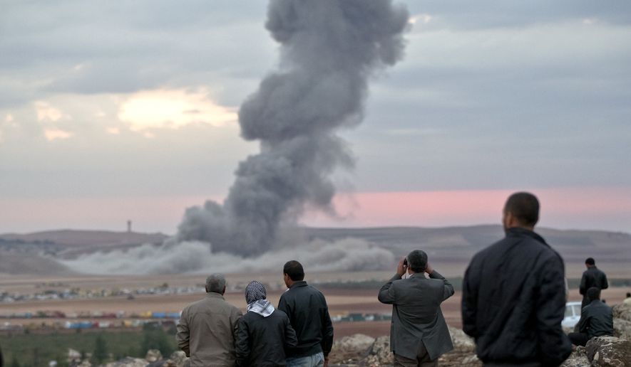 People watch smoke from an airstrike by the US-led coalition rising outside Kobani, Syria, from a hilltop on the outskirts of Suruc, at the Turkey-Syria border, Thursday, Oct. 23, 2014. Kobani, also known as Ayn Arab, and its surrounding areas, has been under assault by extremists of the Islamic State group since mid-September and is being defended by Kurdish fighters. (AP Photo/Vadim Ghirda)