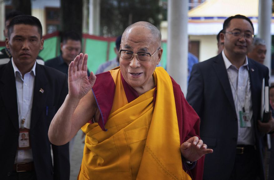 FILE- In this Sept. 24, 2014 file photo, Tibetan spiritual leader the Dalai Lama, center, greets devotees as he arrives at the Tsuglakhang temple for a religious talk in Dharmsala, India. The Dalai Lama is continuing his round of appearances in Boston. The Tibetan spiritual leader will speak Friday morning, Oct. 31, 2014, at the Boston Marriott Copley during an event organized by the Mind and Life Institute, a nonprofit organization focused on understanding the human mind. (AP Photo/Ashwini Bhatia, File)