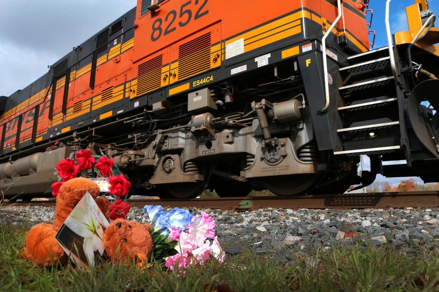 A tiny memorial sits beside the railroad tracks in downtown Vandalia on Friday, Oct. 31, 2014 where four members of a Greenville family were killed Thursday evening when a woman drove her SUV around safety gates. A freight train struck the vehicle. (AP Photo/St. Louis Post-Dispatch, Robert Cohen)