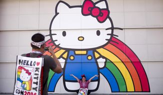 Keith Nunez, left, takes pictures of his wife, Carolina, at the first-ever Hello Kitty fan convention,  Hello Kitty Con, held at the Geffen Contemporary at MOCA, Thursday, Oct. 30, 2014, in Los Angeles. The convention was held to honor the character&#39;s 40th birthday. (AP Photo/Jae C. Hong)