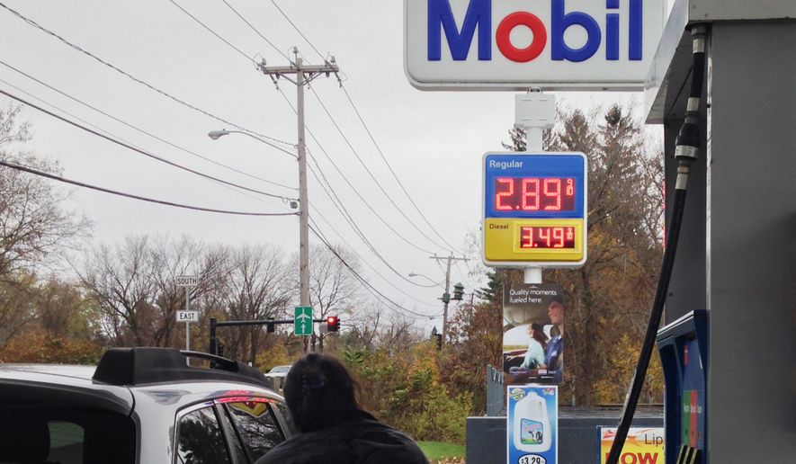 A customer pumps gas in Pittsfield, Mass., where gas prices have fallen below $3 per gallon, Saturday, Nov. 1, 2014. A gallon of regular gas at the station was going for $2.89. (AP Photo/Barbara Woike)