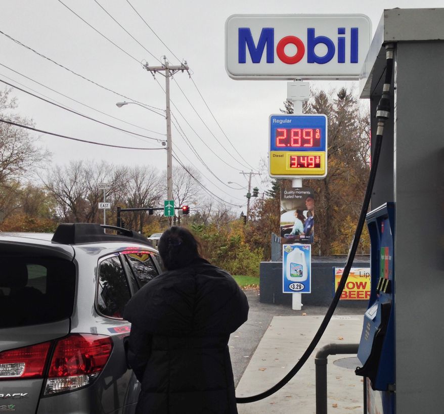 A customer pumps gas in Pittsfield, Mass., where gas prices have fallen below $3 per gallon, Saturday, Nov. 1, 2014. A gallon of regular gas at the station was going for $2.89. (AP Photo/Barbara Woike)
