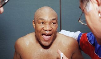 A jubilant George Foreman talks with one of his corner men in his locker room after knocking out Michael Moorer in the 10th round in Las Vegas on Saturday, Nov. 5, 1994. (AP Photo/Lennox McLendon) **FILE**