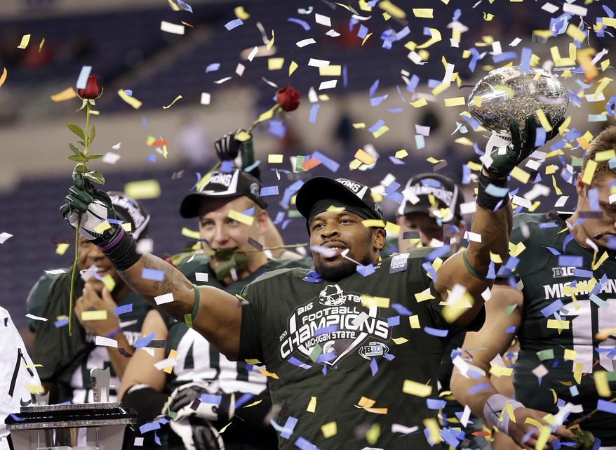 FILE - This Dec. 8, 2013, file photo, shows Michigan State's Denicos Allen holding up the trophy following the Big Ten Conference championship NCAA college football game against Ohio State in Indianapolis. Just as No. 13 Ohio State has been waiting for 11 months for another shot at Michigan State, watchers of the Buckeyes have been waiting to see what they might do against a team with comparable talent. After six straight games beating up on lesser opponents, now the Buckeyes, and their doubters, will see just how good they are. (AP Photo/AJ Mast, File)