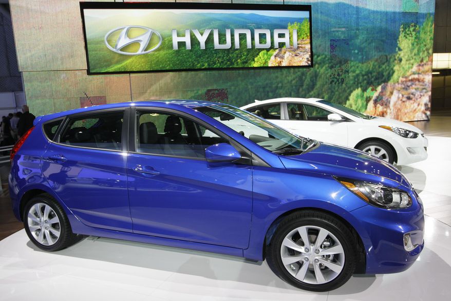 FILE - This April 20, 2011 file photo shows the Hyundai Accent, foreground, and Elantra on display at the New York International Auto Show, in New York. Korean automakers Hyundai and Kia will pay the U.S. government a $100 million civil penalty to end a two-year investigation into overstated gas mileage figures on window stickers of 13 models, the Justice Department and Environmental Protection Agency announced Monday, Nov. 3, 2014. (AP Photo/Mary Altaffer, File)