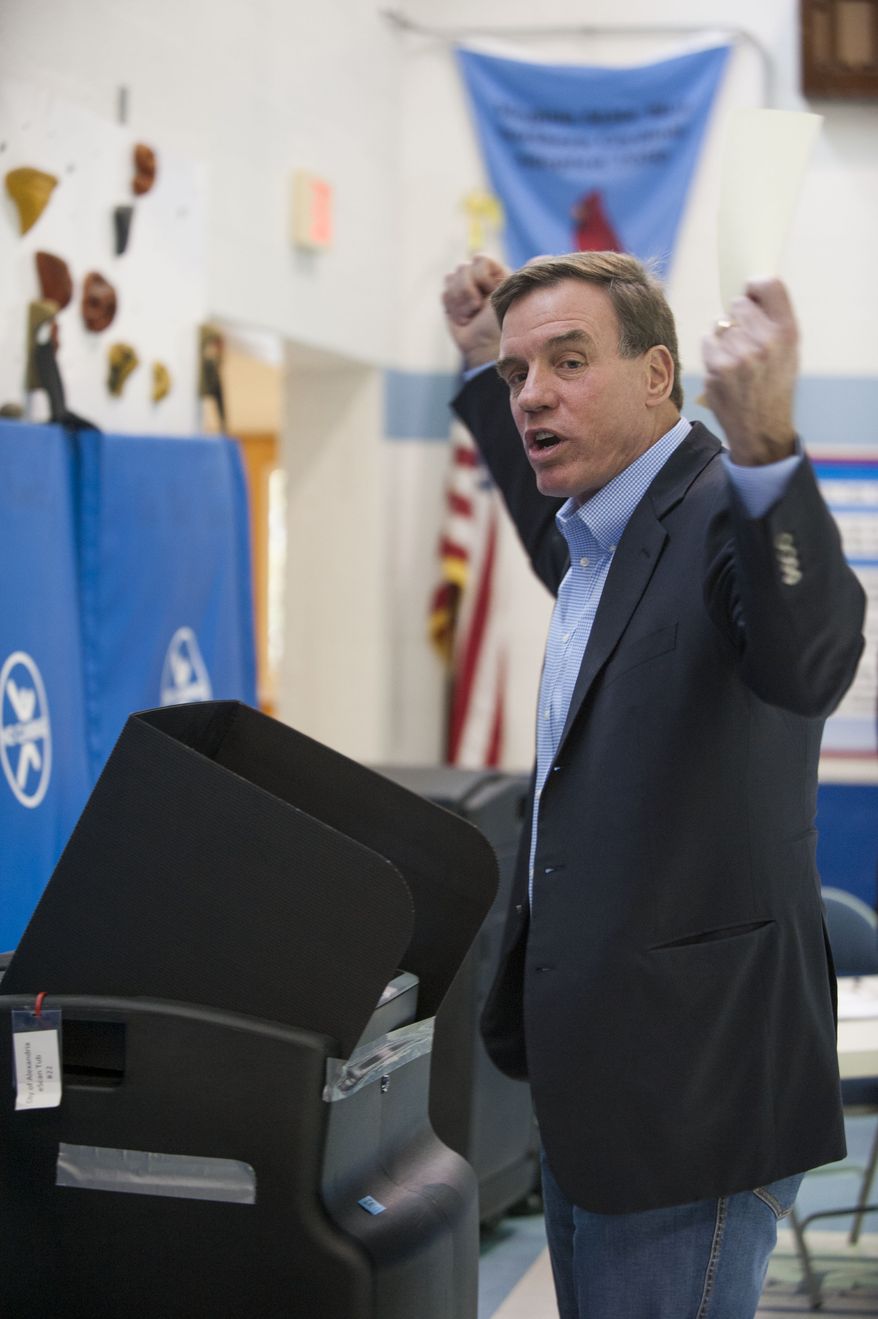 Sen. Mark Warner, D-Va., celebrates after registering his vote at Lyles-Crouch Traditional Academy on Tuesday, Nov. 4, 2014 in Alexandria, Va. Incumbent Democrat Sen. Mark Warner looks to retain his seat in the U.S. Senate for a second term. He faces Republican Ed Gillespie. (AP Photo/Kevin Wolf)