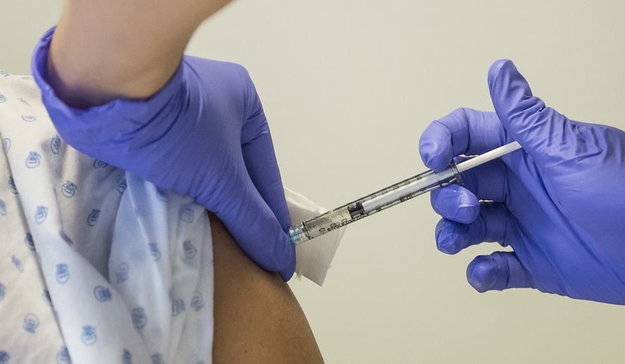A NGO volunteer receives a dose of experimental vaccine &quot;cAd3-EBOZ Lau&quot; from a nurse at the Lausanne University Hospital (CHUV) in Lausanne, Switzerland, Tuesday, Nov. 4, 2014. (AP Photo/Keystone,Jean-Christophe Bott) ** FILE **