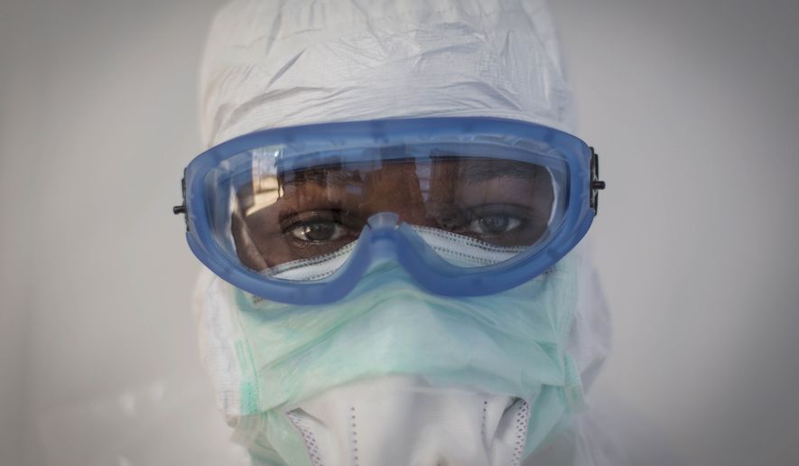 This undated handout photo issued by Save the Children UK on Wednesday shows prospective health care workers in the Kerry Town Ebola Treatment Centre being tested on their personal protection equipment procedure in Sierra Leone. (AP Photo, Louis Leeson/Save the Children UK) ** FILE **