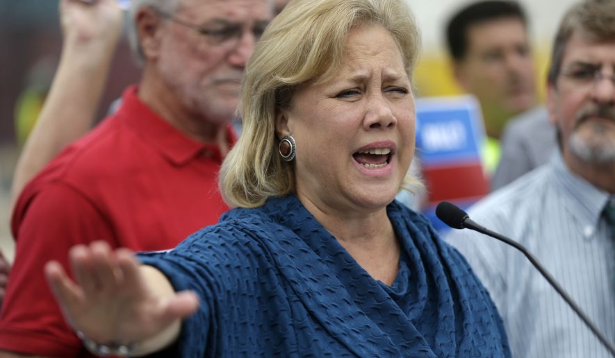 Sen. Mary Landrieu, D-La., speaks to reporters, surrounded by supporters, in front of the New Orleans VA Hospital construction site, the day after being forced into a runoff against her main challenger, Rep. Paul Cassidy, R-La., in New Orleans, Wednesday, Nov. 5, 2014. (AP Photo/Gerald Herbert)