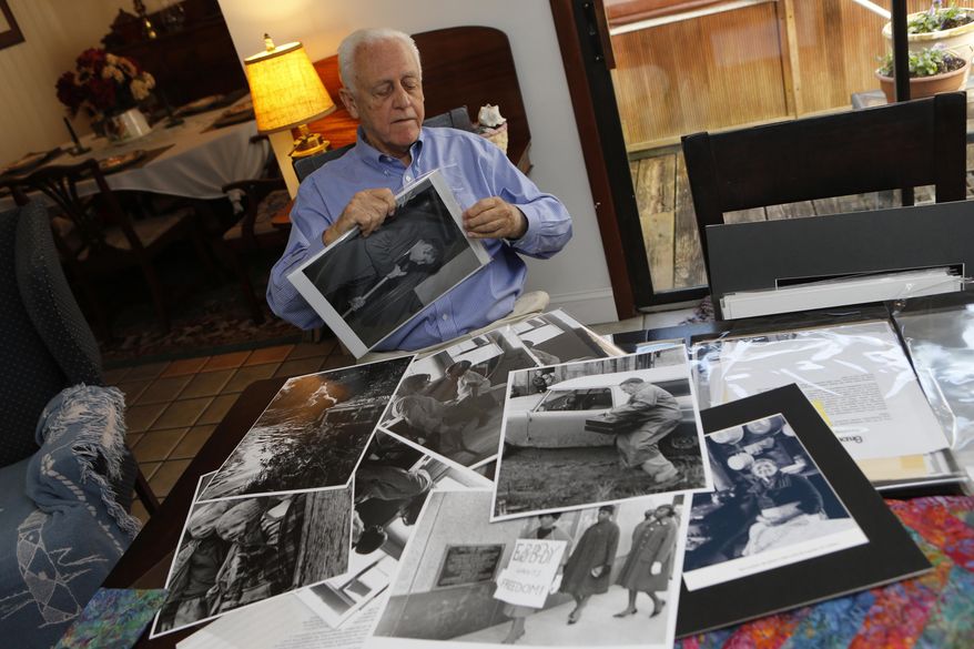 In this photo taken on Oct. 27, 2014, photographer Bruce Roberts sorts through images he's taken over the years at his home in Morehead City, N.C. During his career as a photojournalist, Roberts worked as the director of photography and the senior photographer at Southern Living, as a photographer for The Charlotte Observer during the civil rights movement and freelanced for publications like Sports Illustrated, Time and Life magazines. (AP Photo/The Jacksonville Daily News, John Althouse)