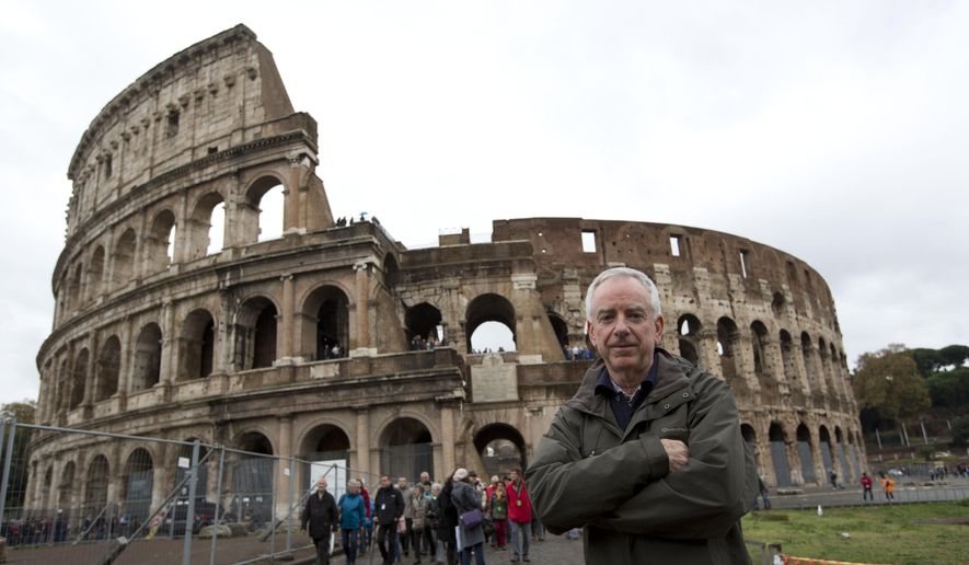 Archaeologist Daniele Manacorda poses in front of Rome's Colosseum Friday Nov.7, 2014. An archaeologist's proposal to return the Colosseum's storied arena to its original state, when gladiators sparred with lion, has sparked a lively debate over appropriate uses of the monument that symbolizes the glories of ancient Rome. (AP Photo/Alessandra Tarantino)