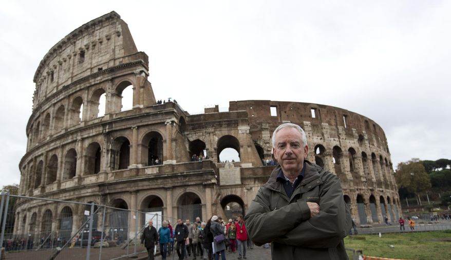 Archaeologist Daniele Manacorda poses in front of Rome's Colosseum Friday Nov.7, 2014. An archaeologist's proposal to return the Colosseum's storied arena to its original state, when gladiators sparred with lion, has sparked a lively debate over appropriate uses of the monument that symbolizes the glories of ancient Rome. (AP Photo/Alessandra Tarantino)