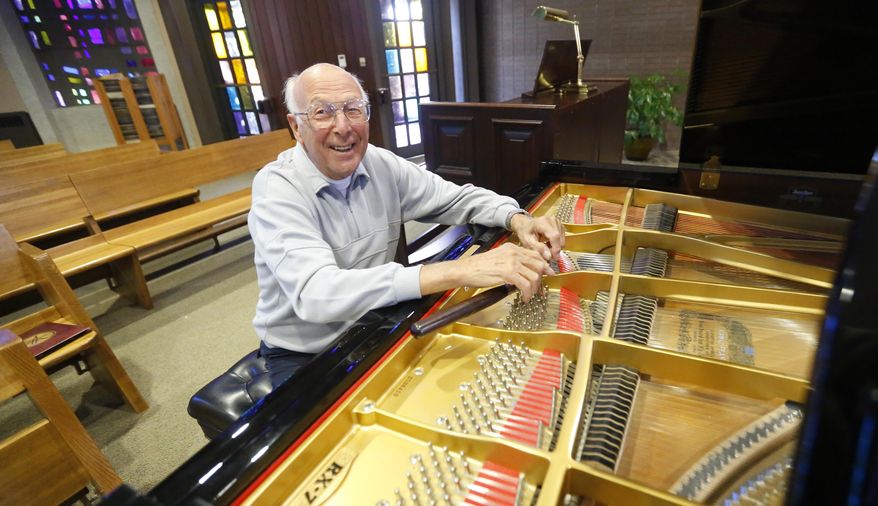 In this Tuesday, Sept. 23, 2014 photo, Gilbert "Gib" Crippes, a longtime piano tuner, poses for a portrait at Saint Joseph the Worker Catholic Church, in Dubuque, Iowa. Crippes doesn't have a musical background or play an instrument, but he's been working with pianos since he was in seventh grade. (AP Photo/The Telegraph Herald, Mike Burley)