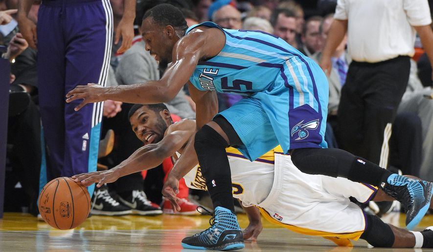 Los Angeles Lakers guard Ronnie Price, below, and Charlotte Hornets guard Kemba Walker go after a loose ball during the first half of an NBA basketball game, Sunday, Nov. 9, 2014, in Los Angeles. (AP Photo/Mark J. Terrill)